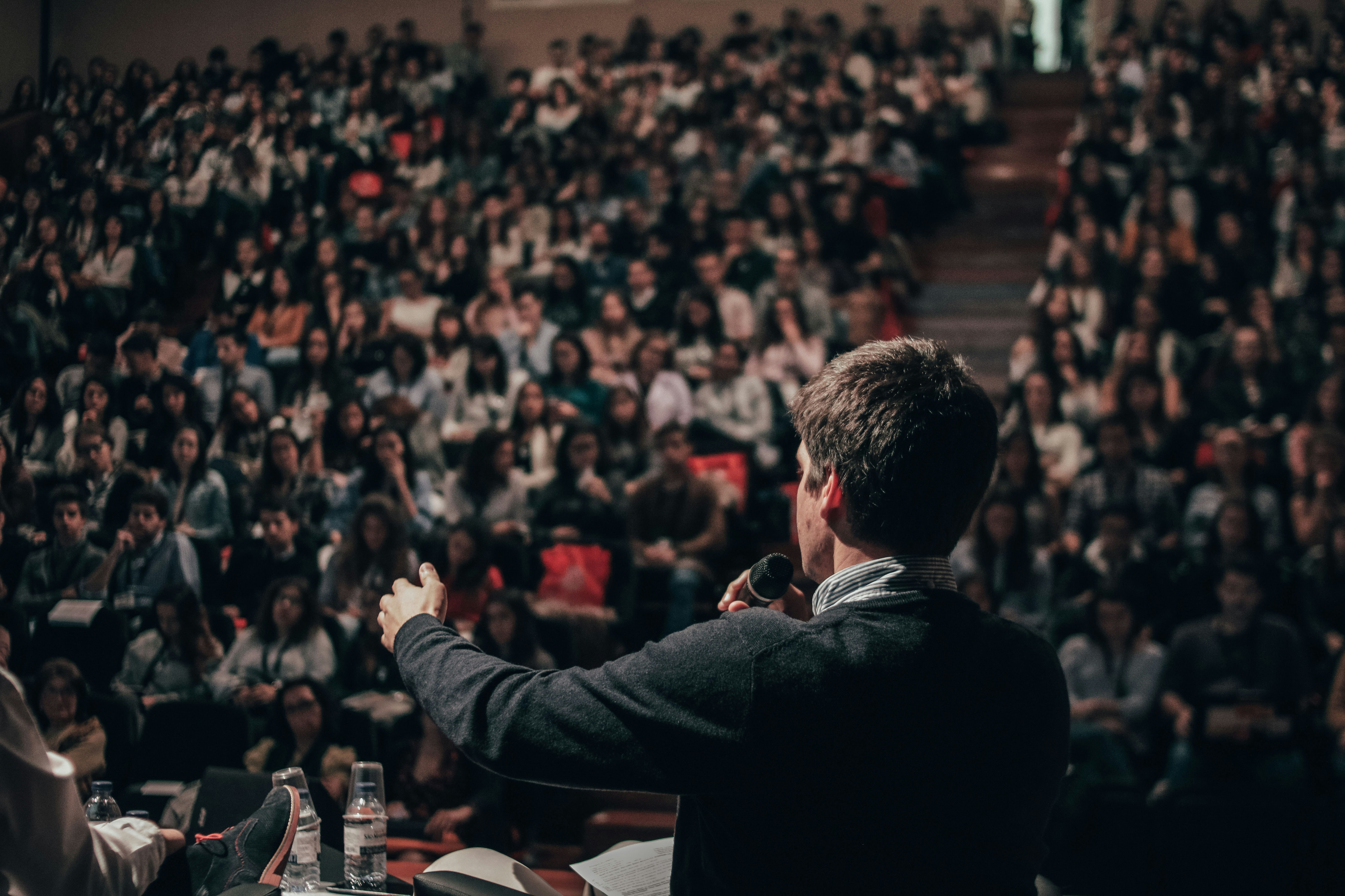 Dozent:in vor großem Auditorium